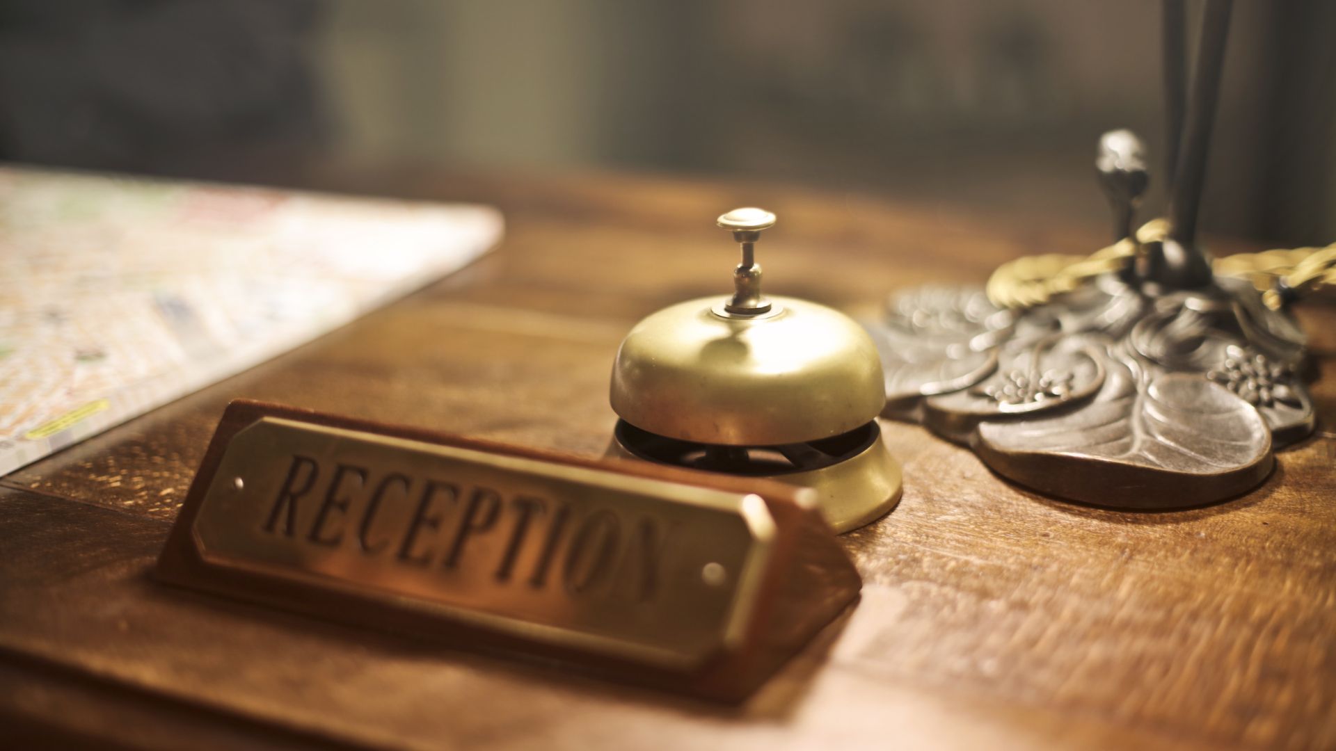 Desk of hotel with bell and reception nameplate