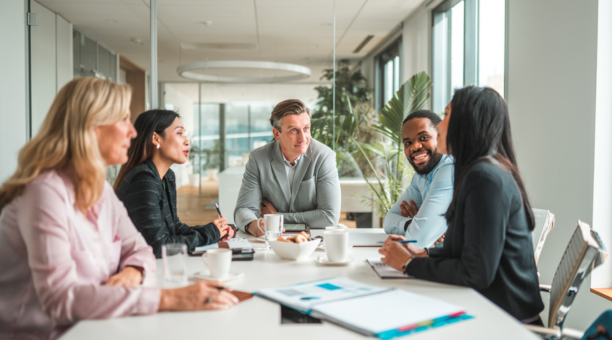 Five employees sitting around a conference table