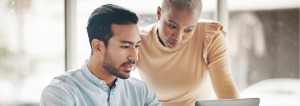 Two employees looking at a laptop together at work. 